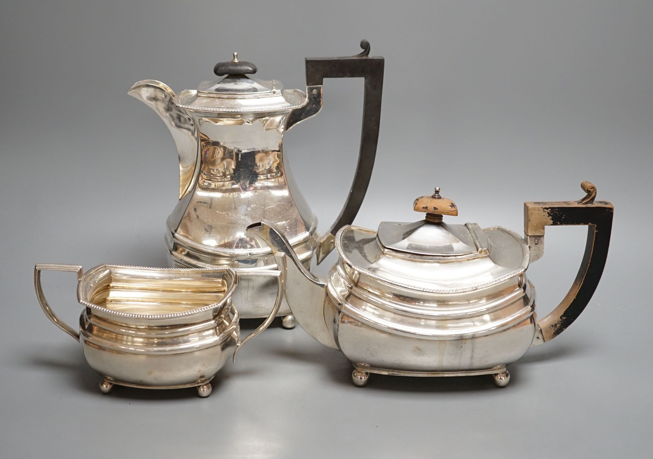 A George V matched silver part tea set, comprising a hot water pot, teapot and sugar bowl, different makers, Birmingham, 1927,8,9, gross 48.5oz.